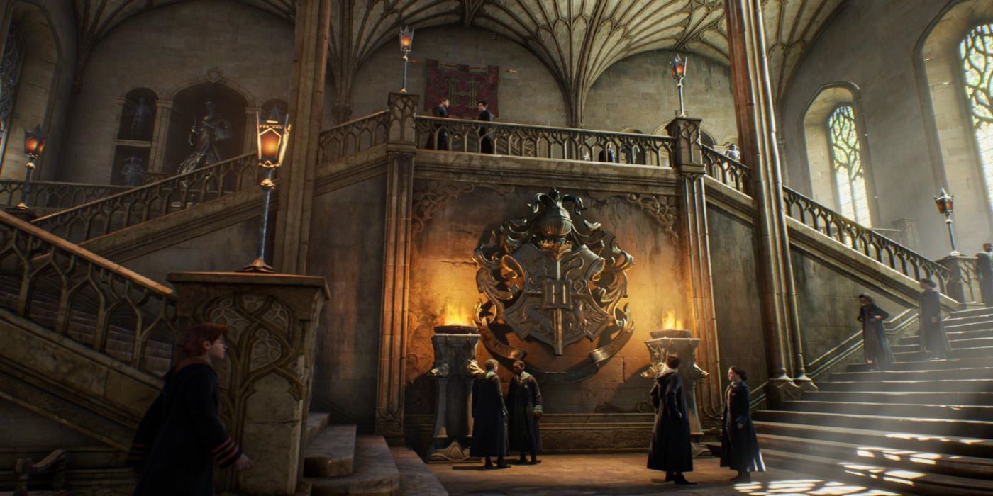 The interior of Hogwarts in Hogwarts legacy with two big stair cases leading either side of a giant hogwarts crest