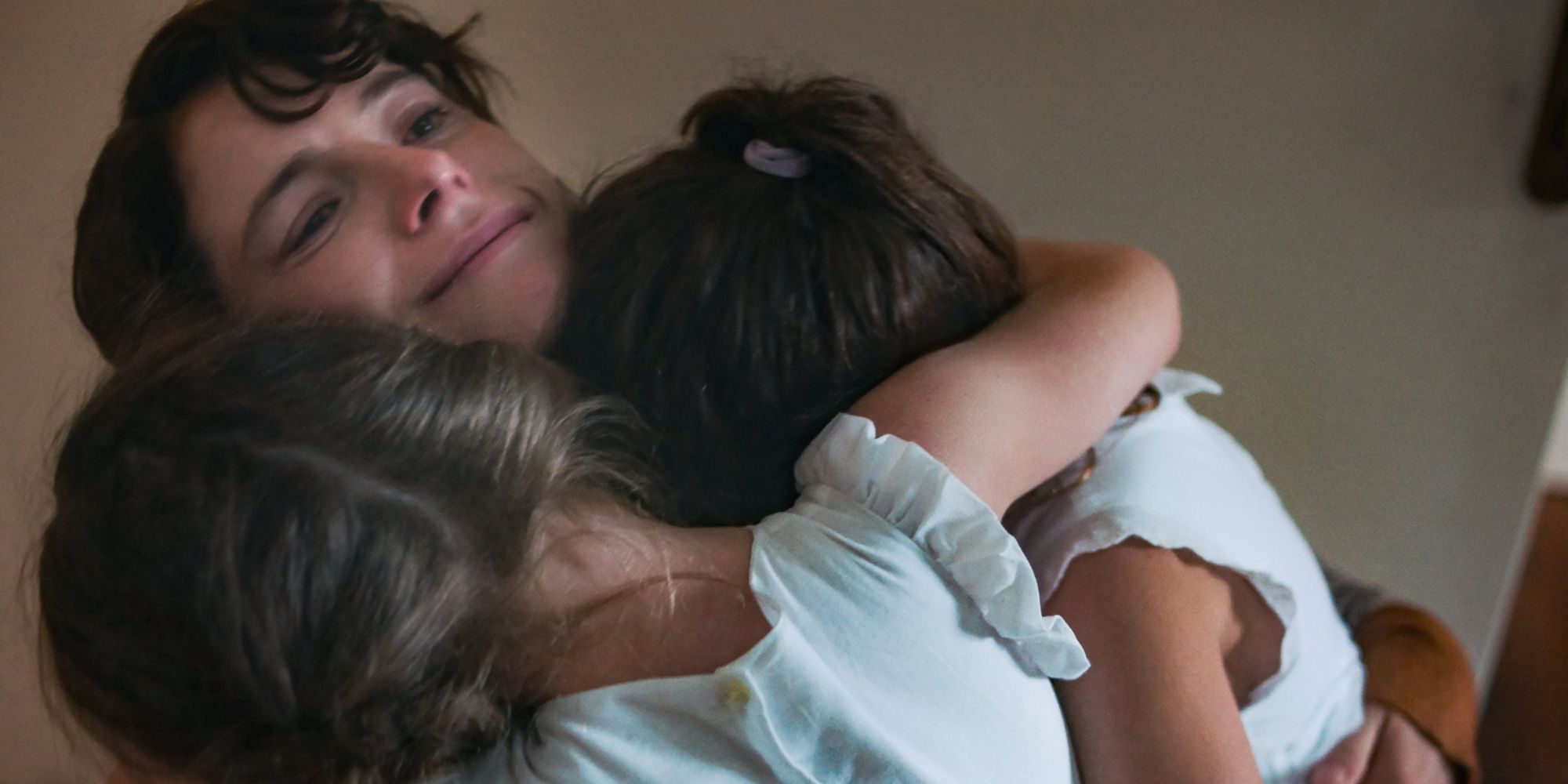 Young Leda (Jessie Buckley) holds her daughters in The Lost Daughter