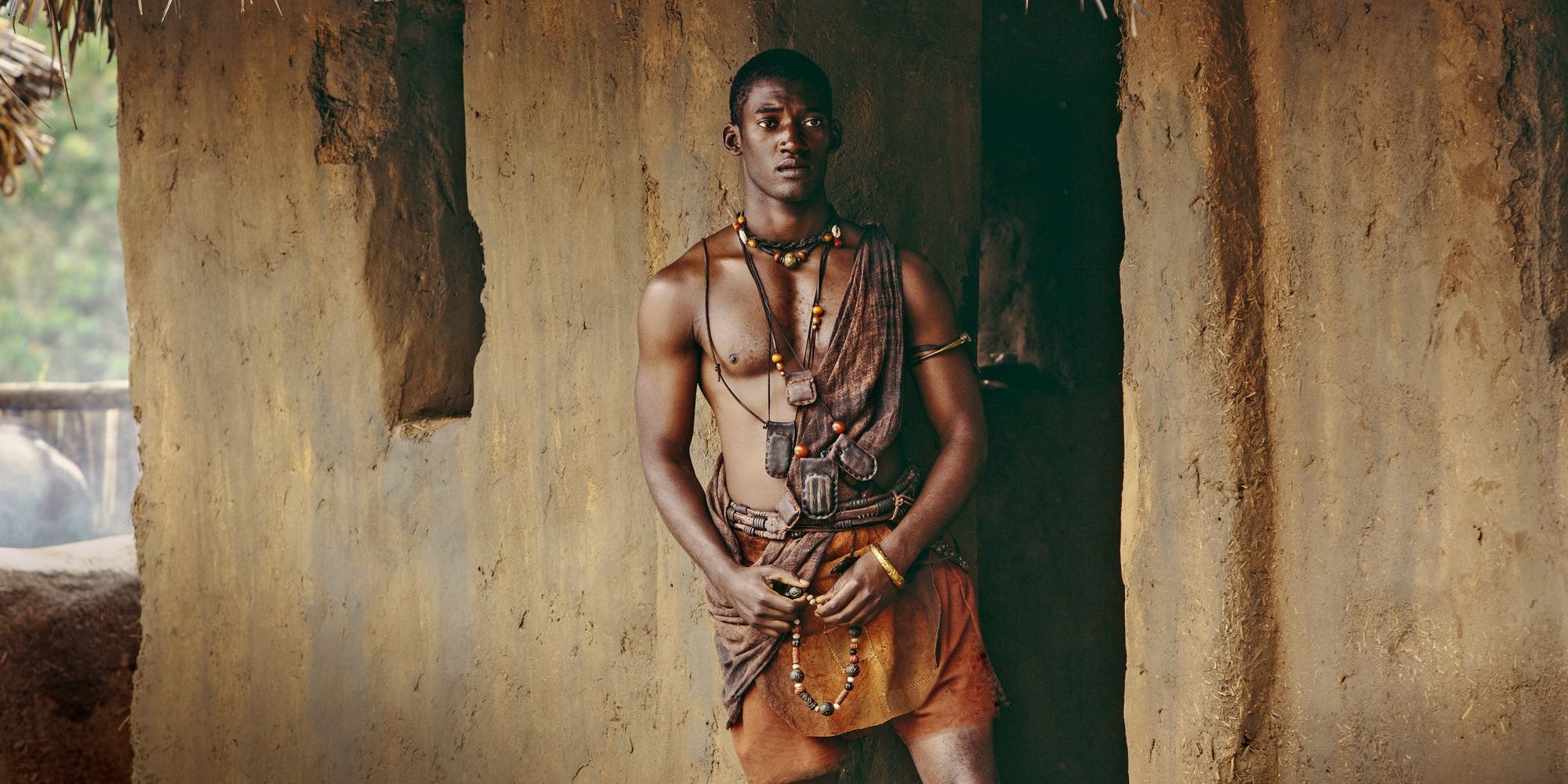Kunta Kinte standing outside a hut in Roots