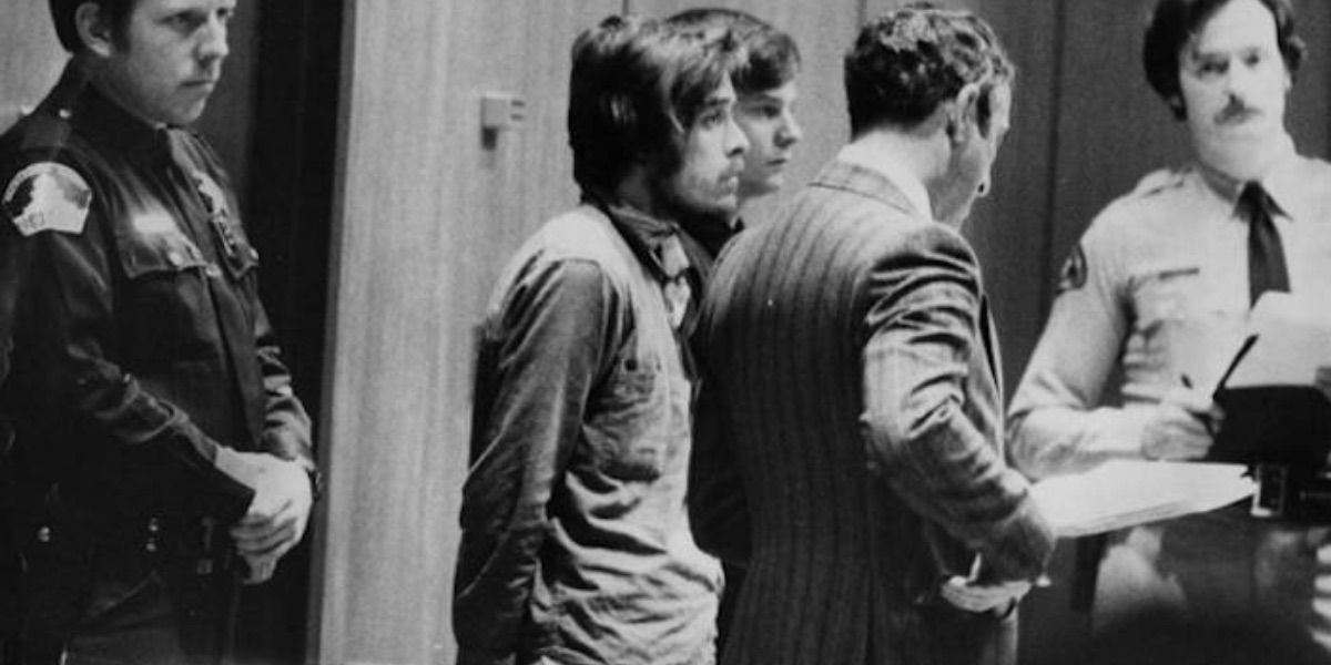 Richard Chase stands handcuffed amongst police officers 