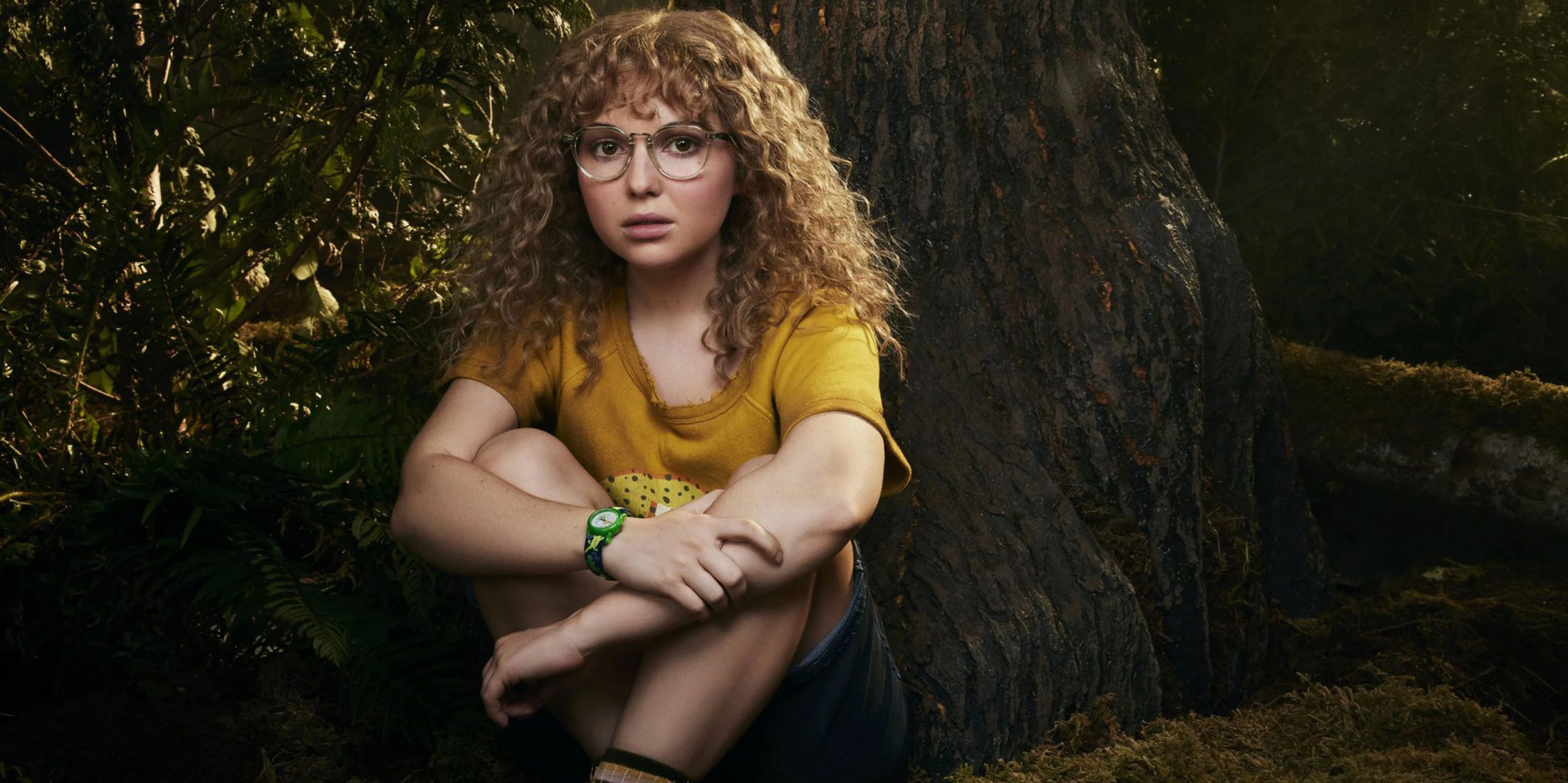 Misty sits in the woods in a promotional image for Yellowjackets