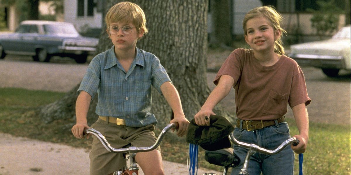 Two children sit on bikes and look on from My Girl