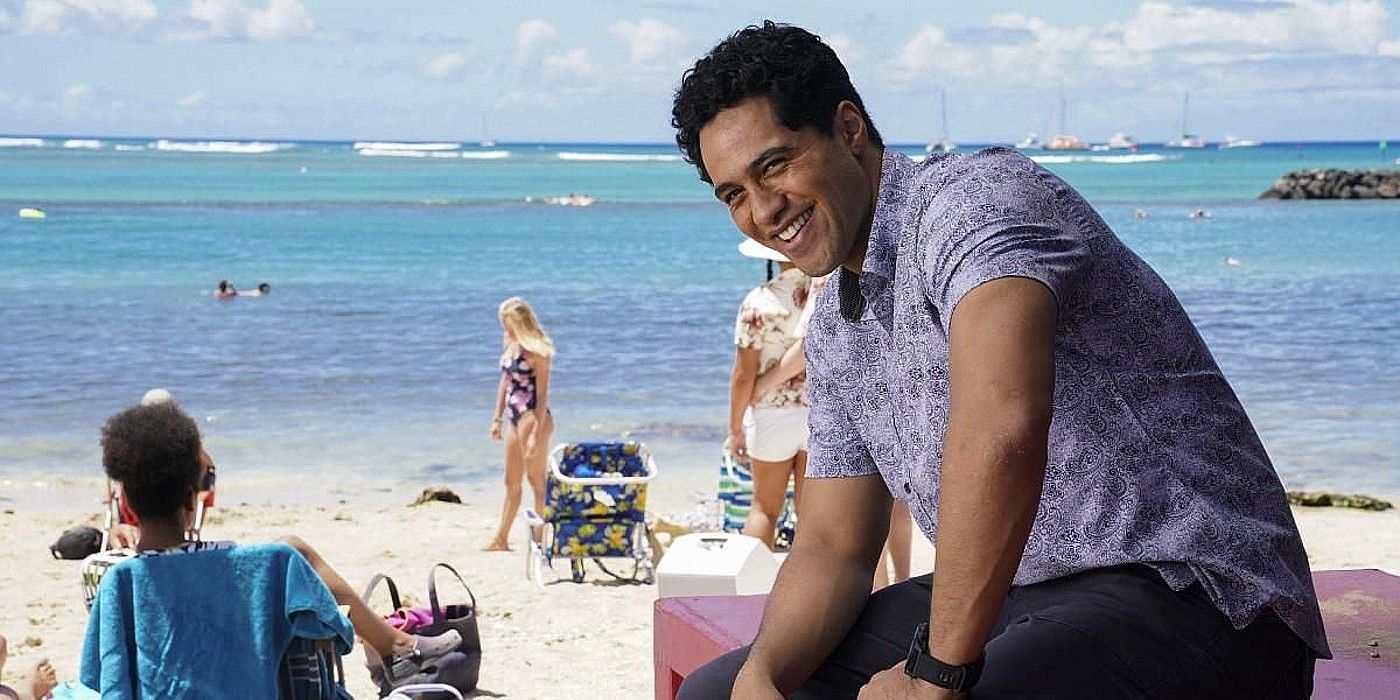 Alex Tarrant as Kai Holman smiling on the beach in NCIS Hawaii