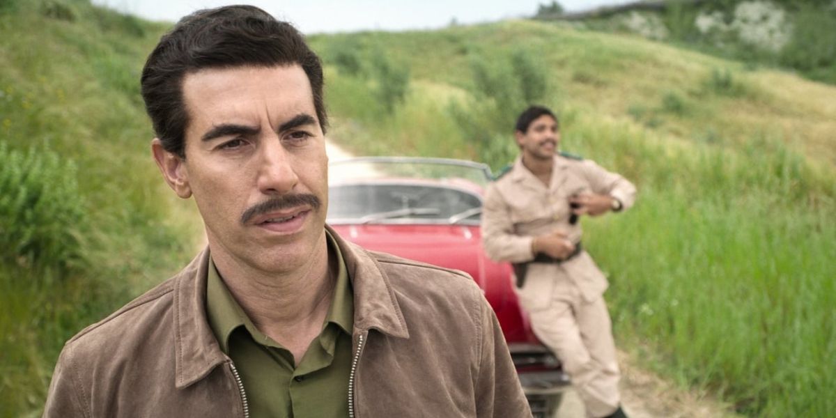 Sacha Baron Cohen as Eli Cohen standing on a dirt road in Netflix's The Spy