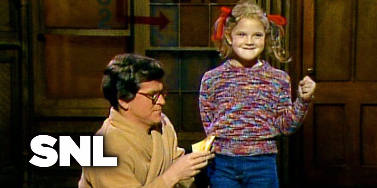 Drew Barrymore hears audience questions from a person kneeling beside her from SNL