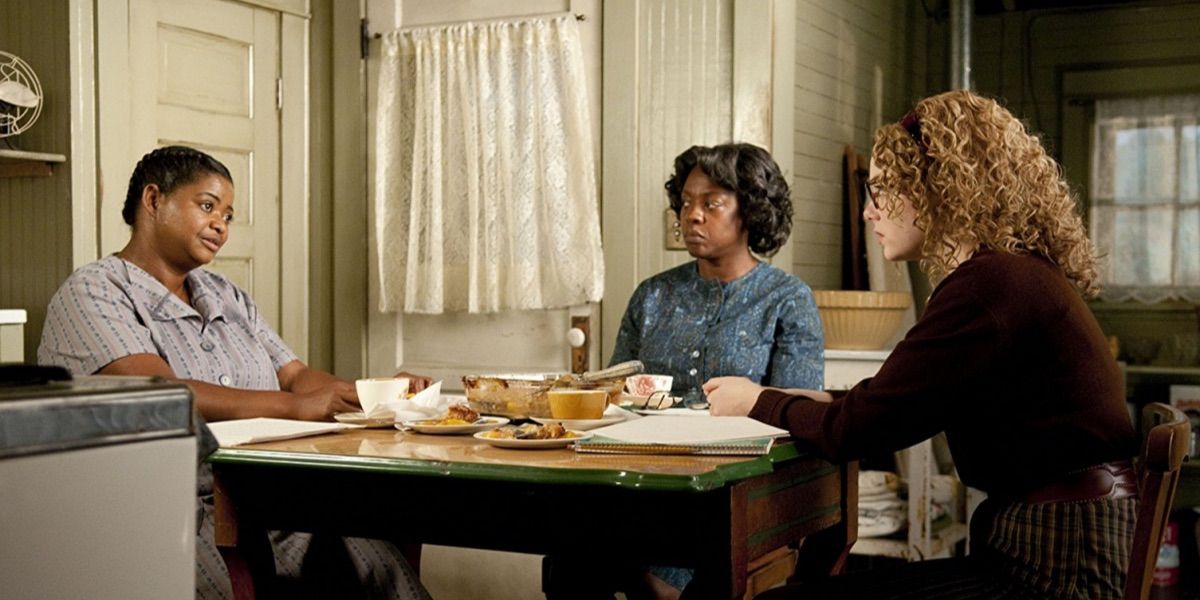 Octavia Spencer, Viola Davis, and Emma Stone talk at a kitchen table from The Help