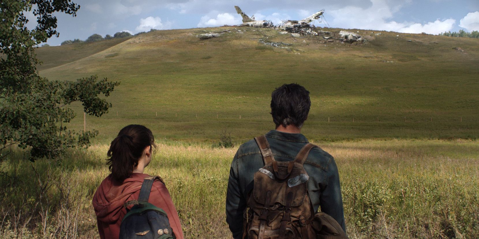 Joel and Ellie satre at a crash site in a field in The Last Of Us.