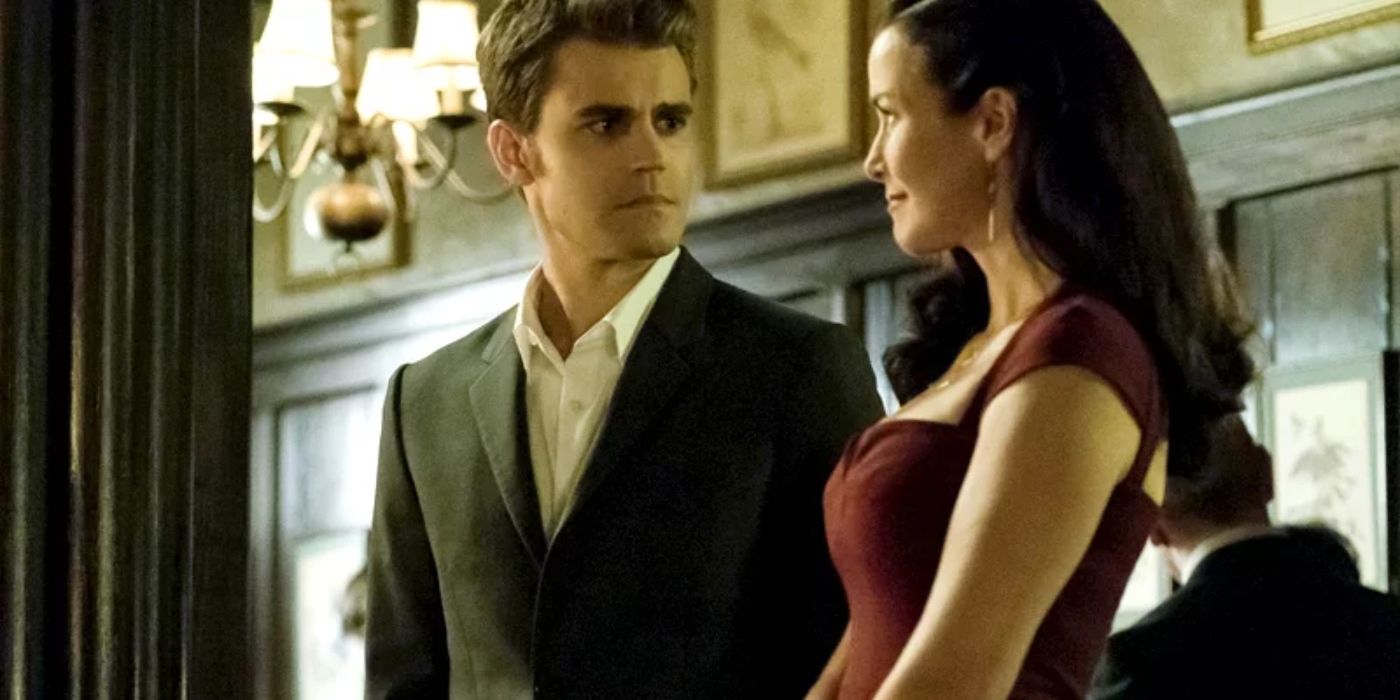 Stefan e Lily se olhando em roupas extravagantes em The Vampire Diaries