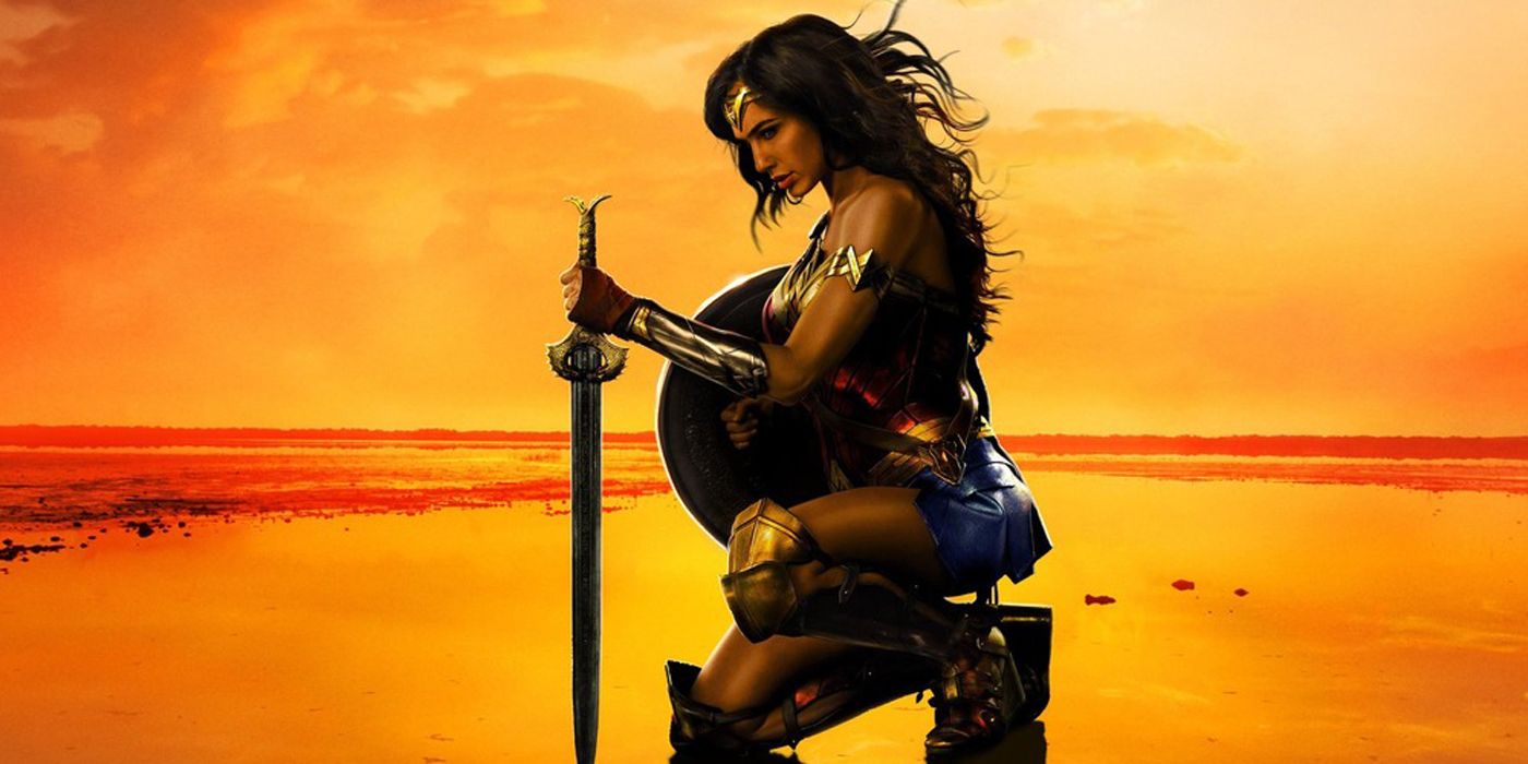 Wonder Woman kneeling on a beach in the movie.