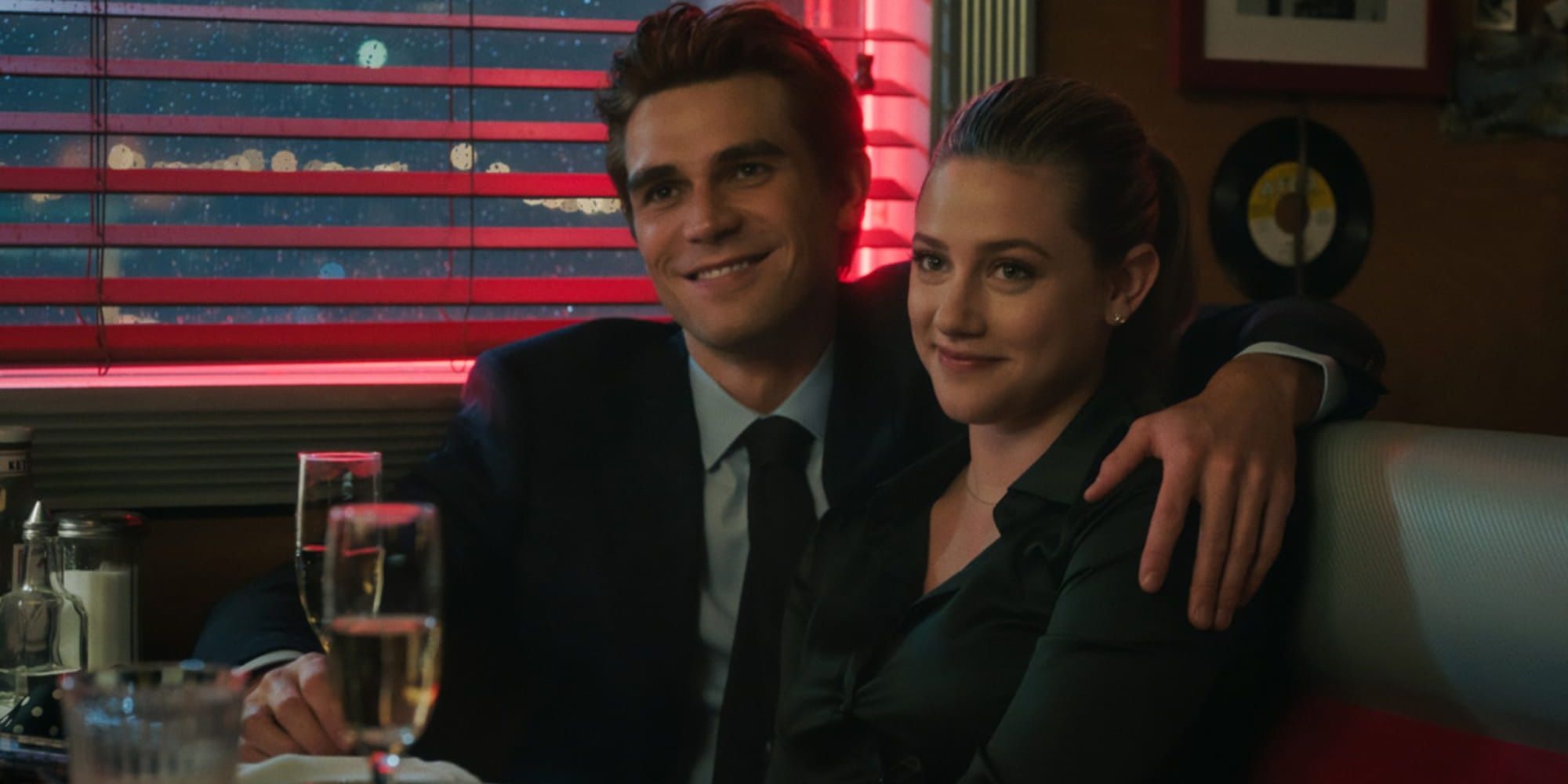 Betty and Archie sit in a diner's booth on Riverdale