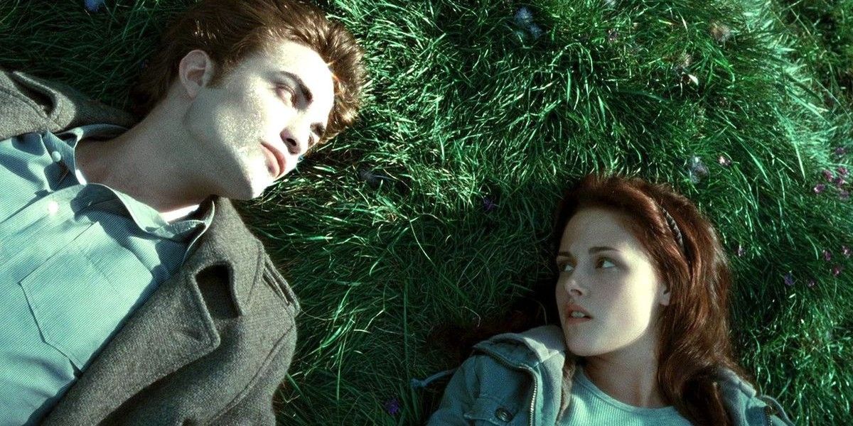 Bella e Edward deitados na grama.
