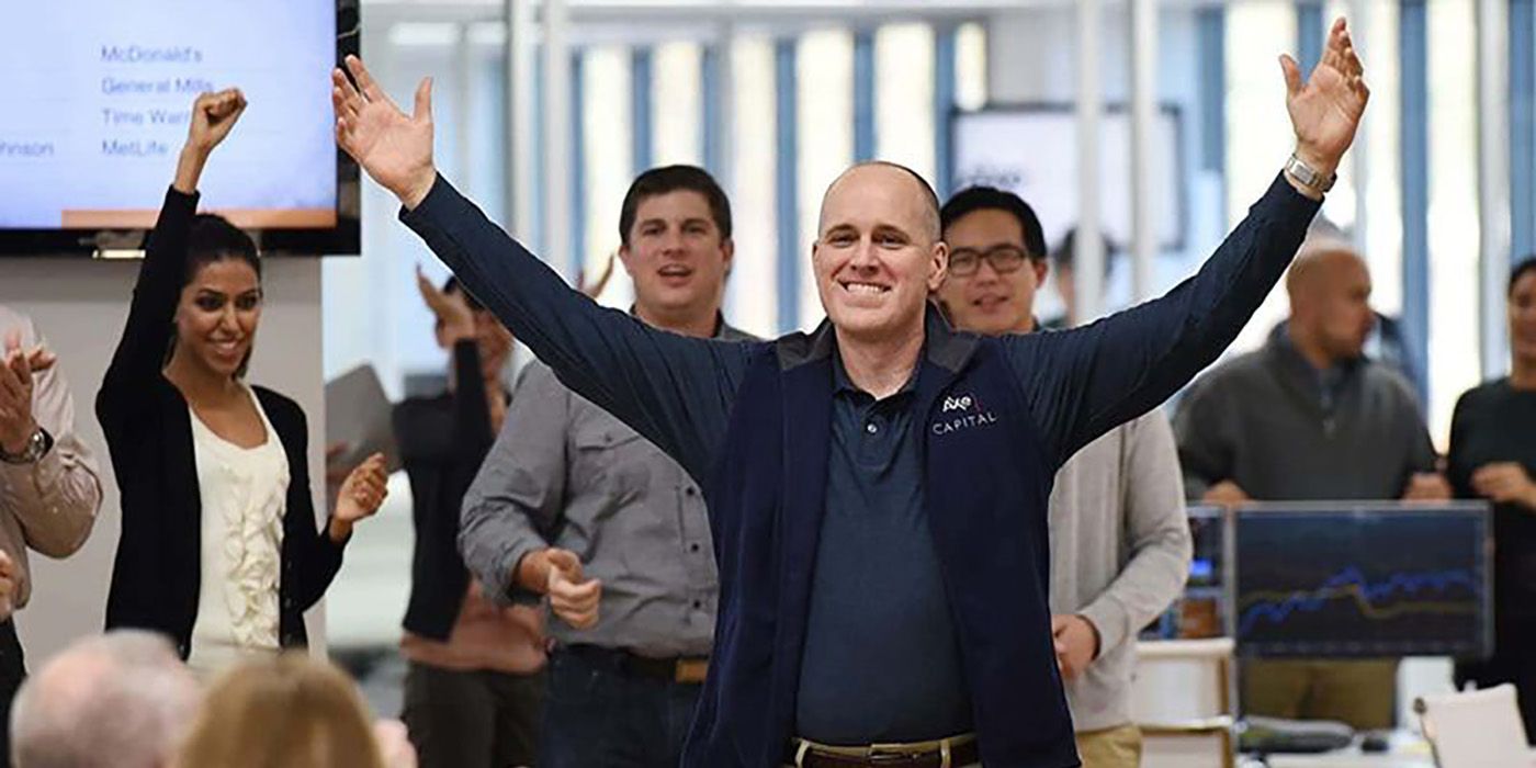 Dollar Bill at Axe Capital raising his arms in the air smiling, the team behind him on Billions.