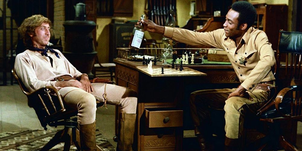 Bart hands a bottle to Jim in Blazing Saddles
