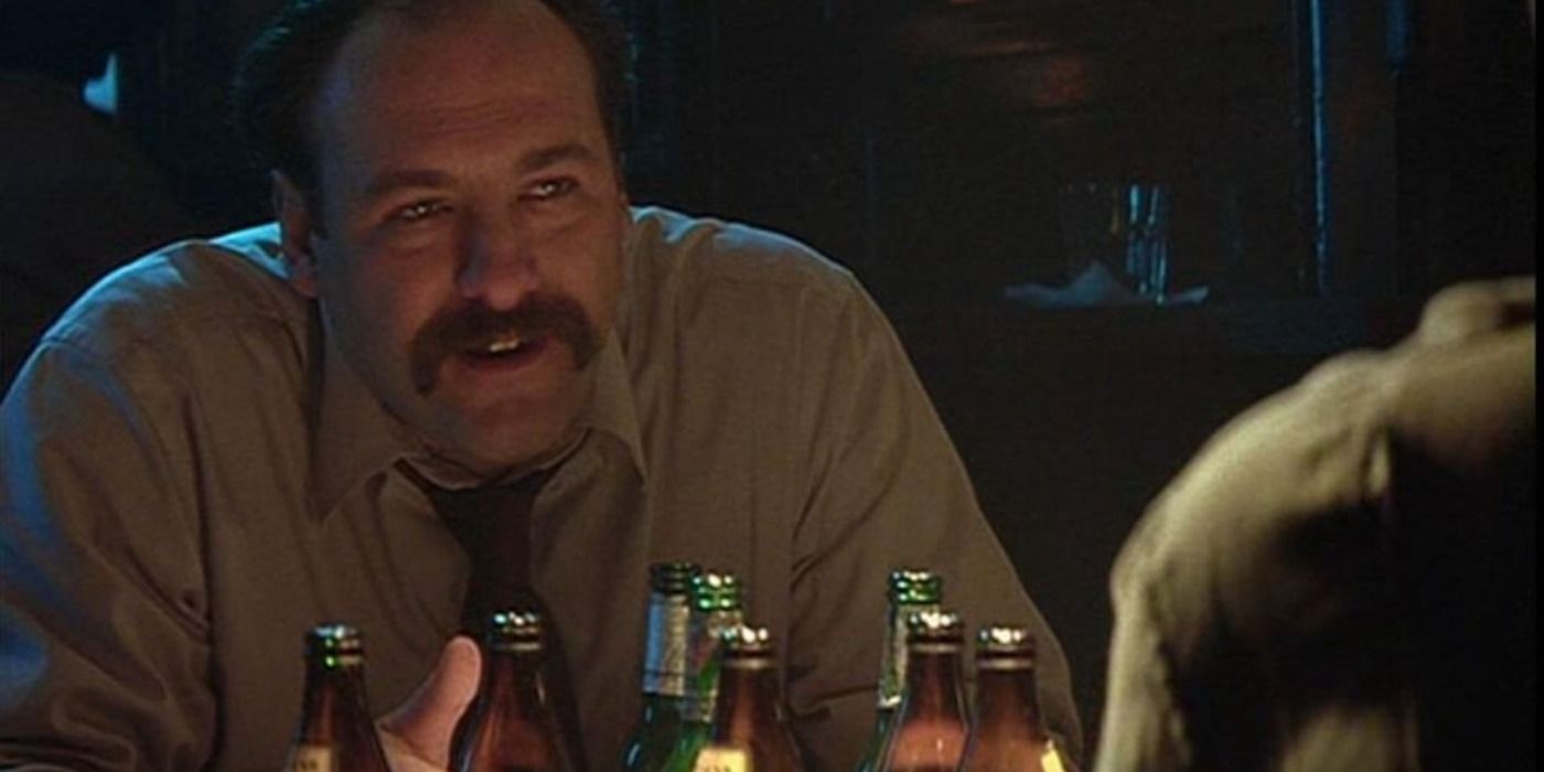 James Gandolfini with a mustache in front of beer bottles in Fallen.