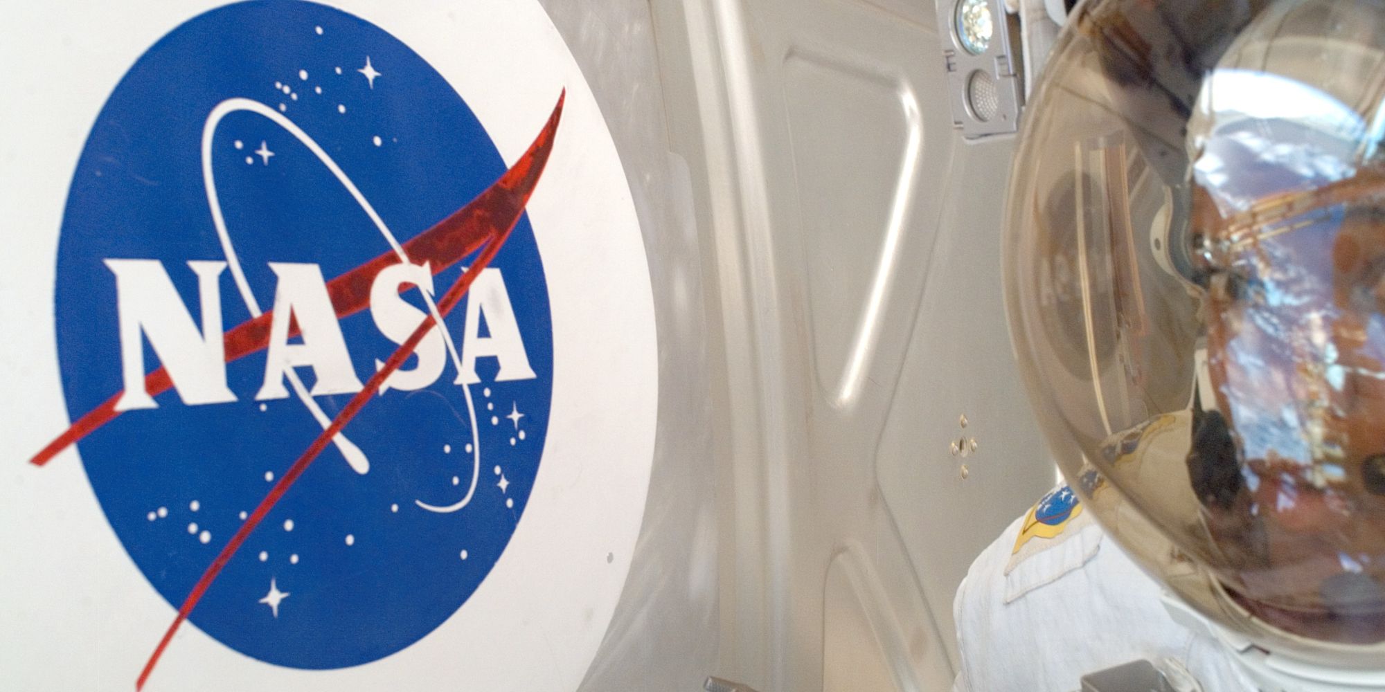 Photo of an astronaut looking at the NASA logo