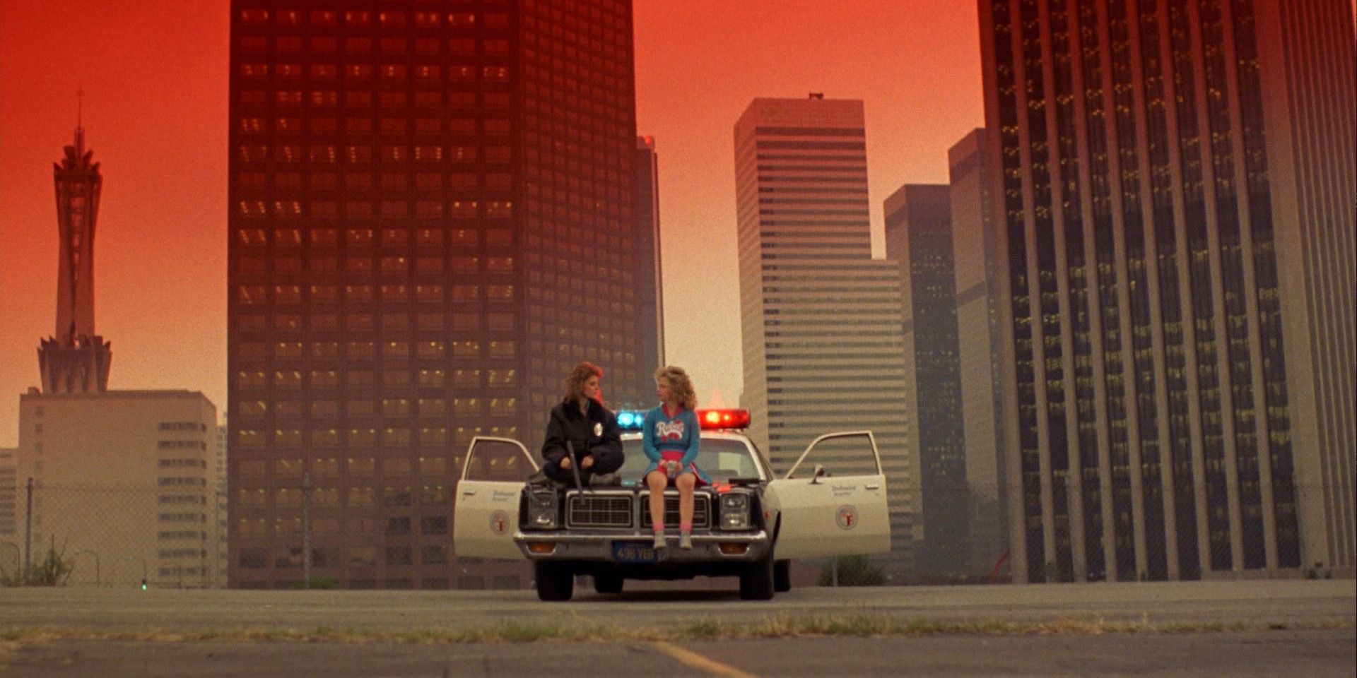 Reggie and Sam sitting on a cop car in Night of the Comet.