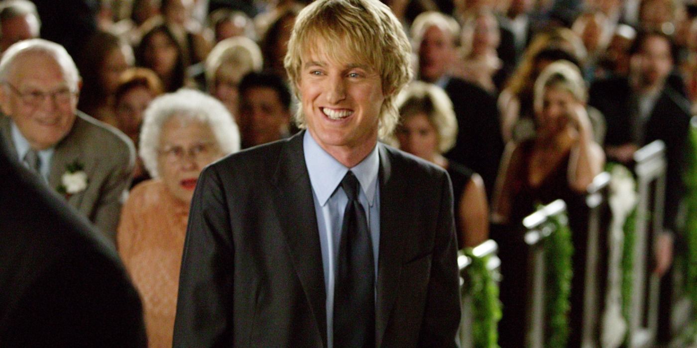 Owen Wilson standing in a church wearing a suit in Wedding Crashers.