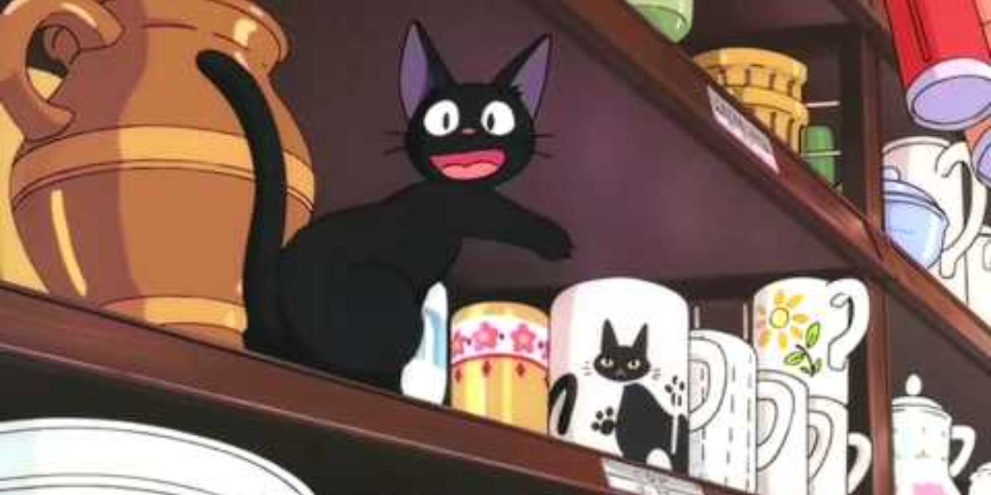 Jiji happily pointing to a coffee cup with a black cat on it on Kiki's Delivery Service
