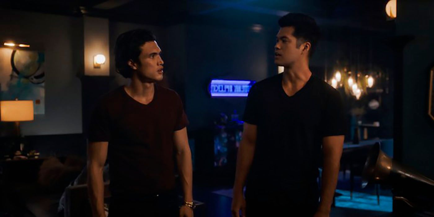 Both actors who played Reggie Mantle on Riverdale looking at one another, wearing black T-shirts.