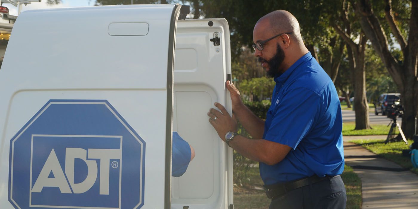 The CEO of ADT standing at the back of a company truck from an episode of Undercover Boss.