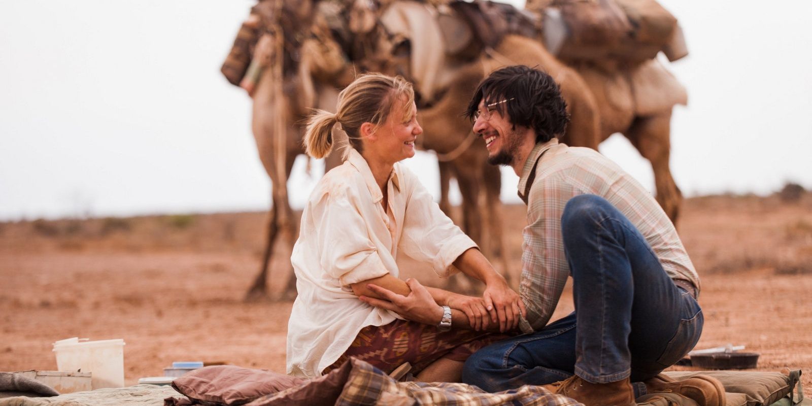 A man and woman laugh in the desert in Tracks
