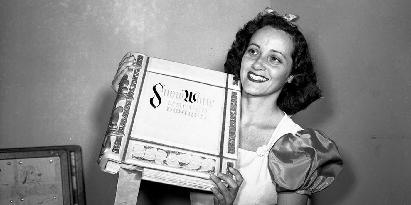 Adriana Caselotti as Snow White posing with the book