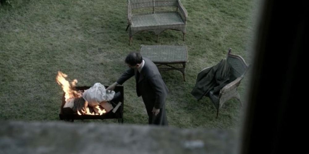 An image of Frank burning Claire's dress in Outlander