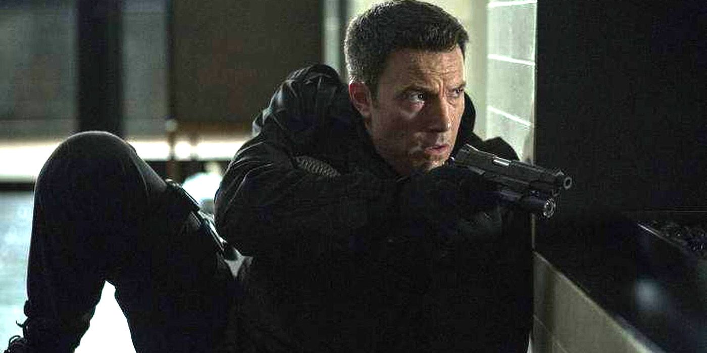 Ben Affleck's Christian taking cover and pointing a gun in The Accountant
