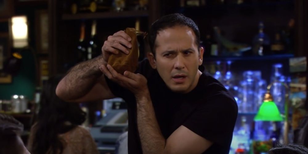 Carl the Bartender holds up a bag in How I Met Your Mother
