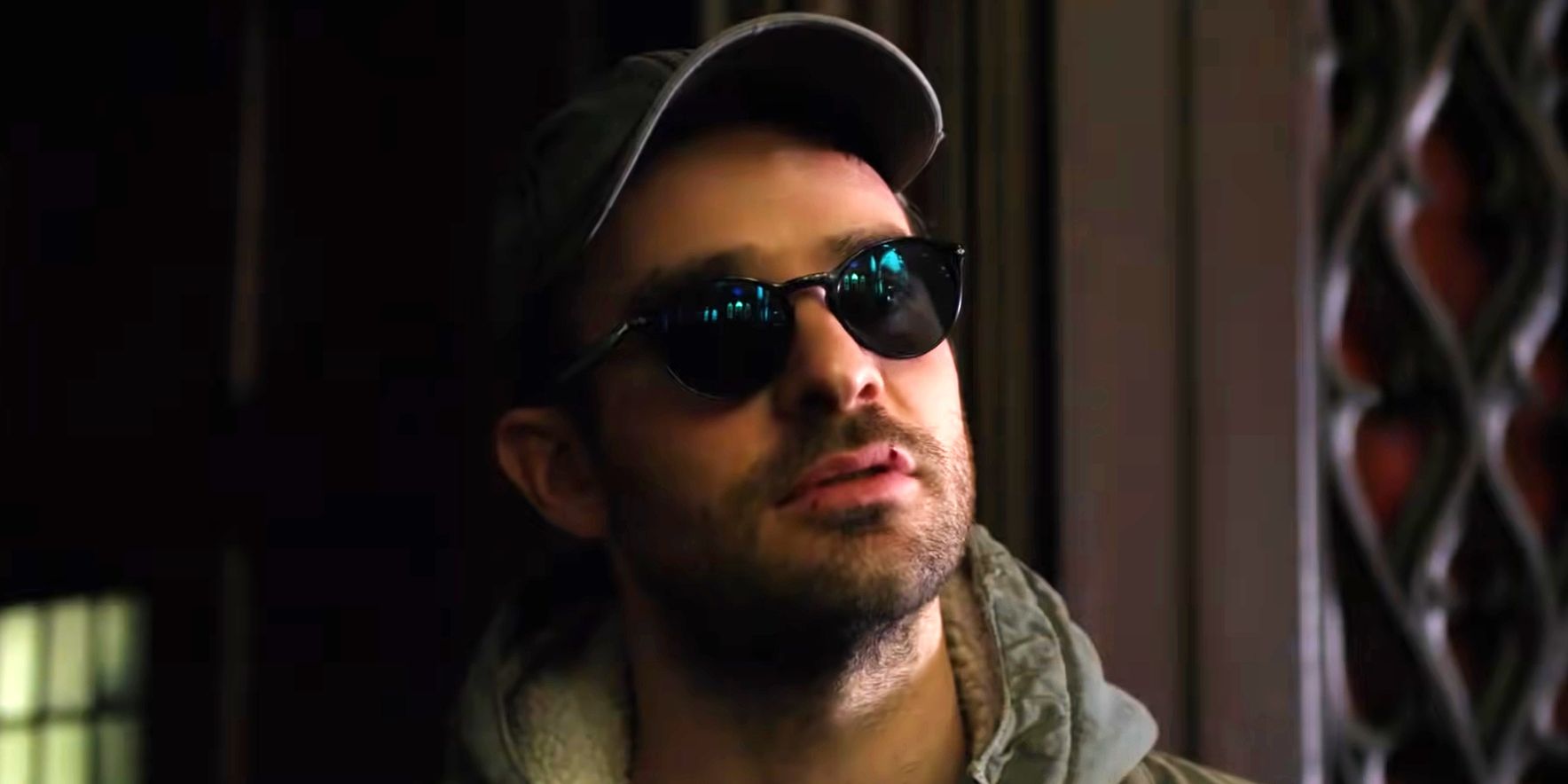 Matt Murdock wearing a cap and talking to someone off-camera in Daredevil.
