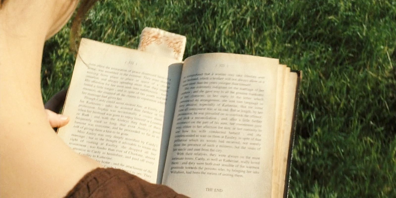Elizabeth Bennett in Pride &amp; Prejudice shown from behind while walking and reading a book.