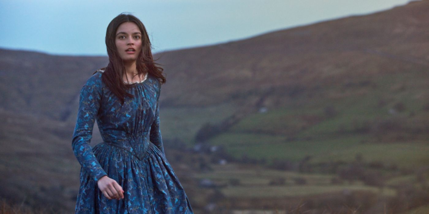 Emily Bronte standing in an open field in the movie Emily