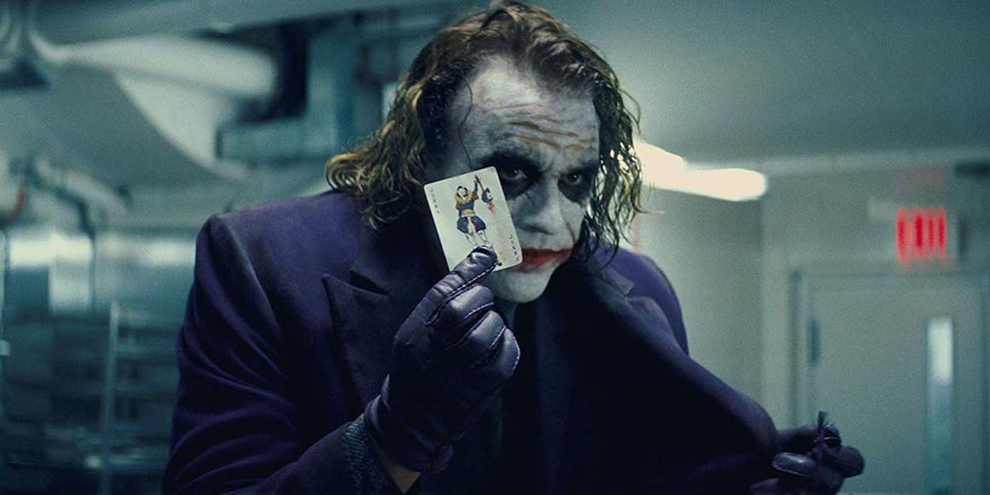 Joker holding up a playing card in Dark Knight.