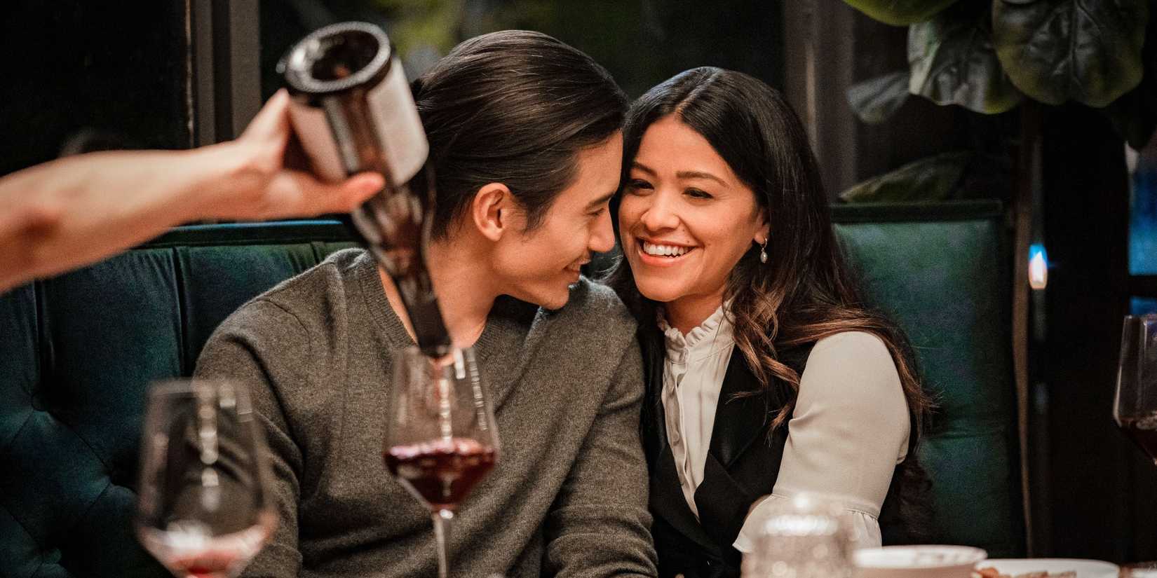 Manny Jacinto and Gina Rodriguez snuggled up together in a restaurant booth in I Want You Back