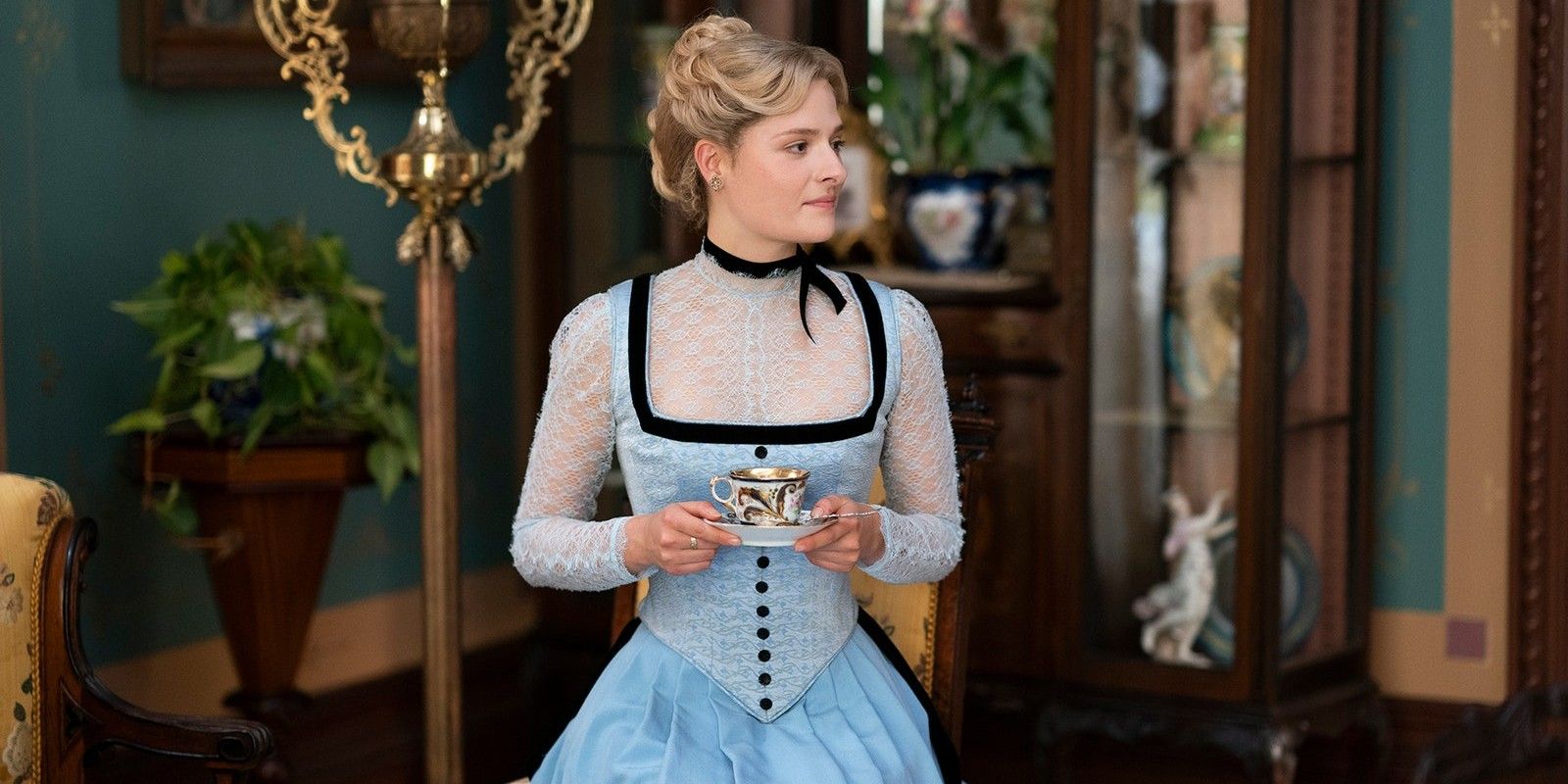 Marian Brook holding a cup of Tea in The Gilded Age