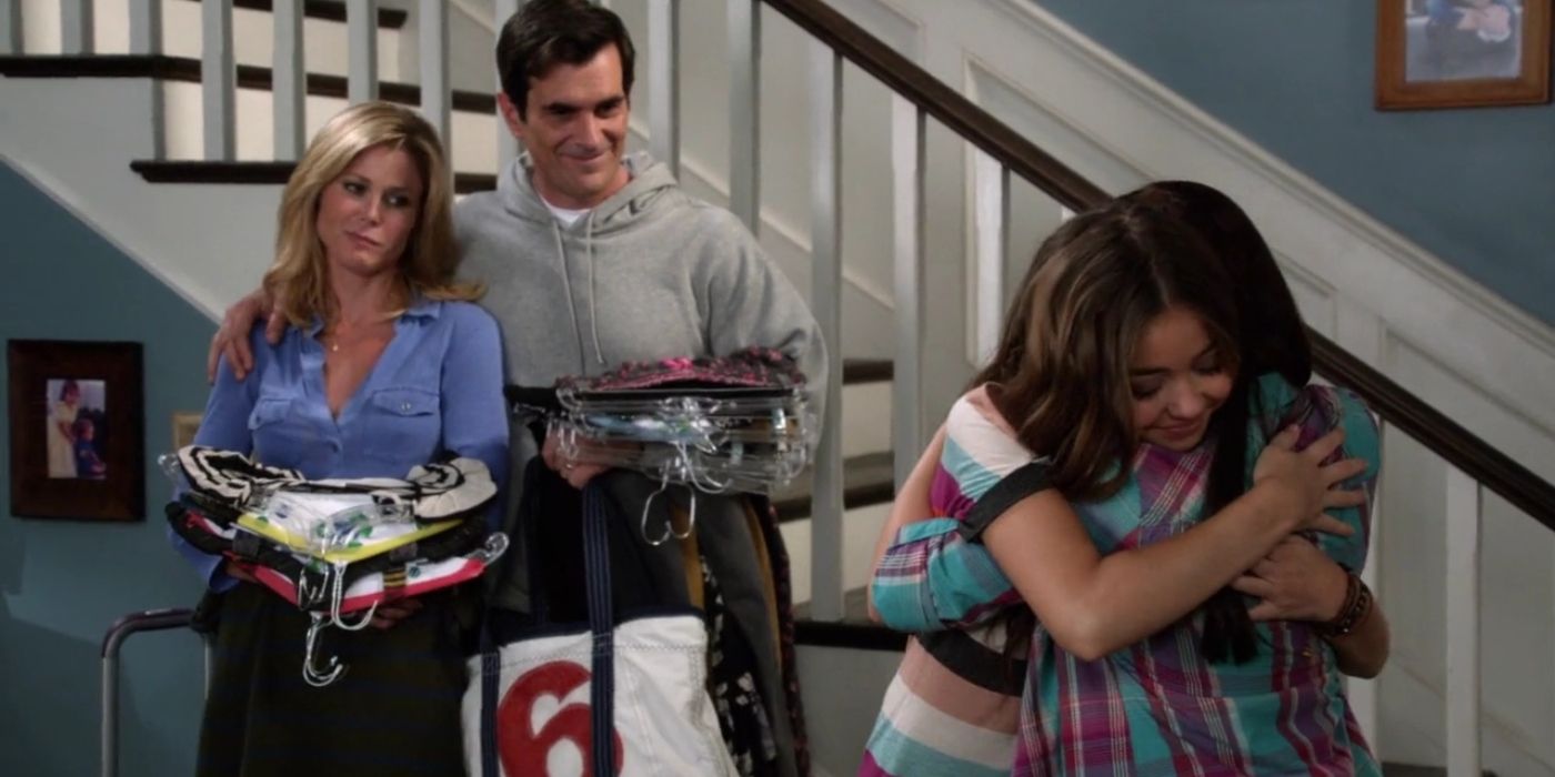 Claire and Phil smiling as Alex and Haley hug on Modern Family