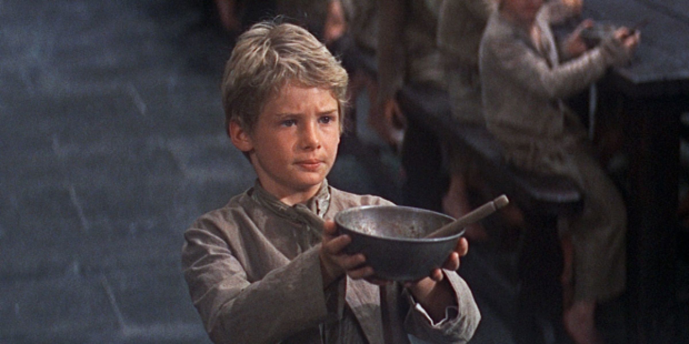 A kid holding a bowl in Oliver!