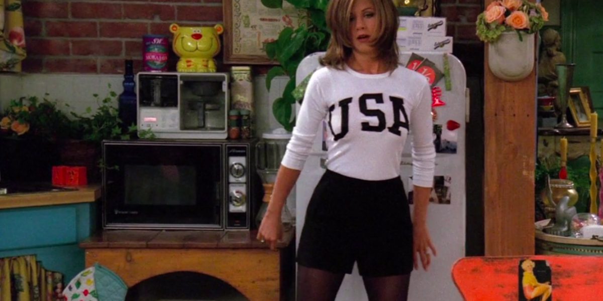 Rachel Green wearing a USA sweater, black shorts, and black tights.