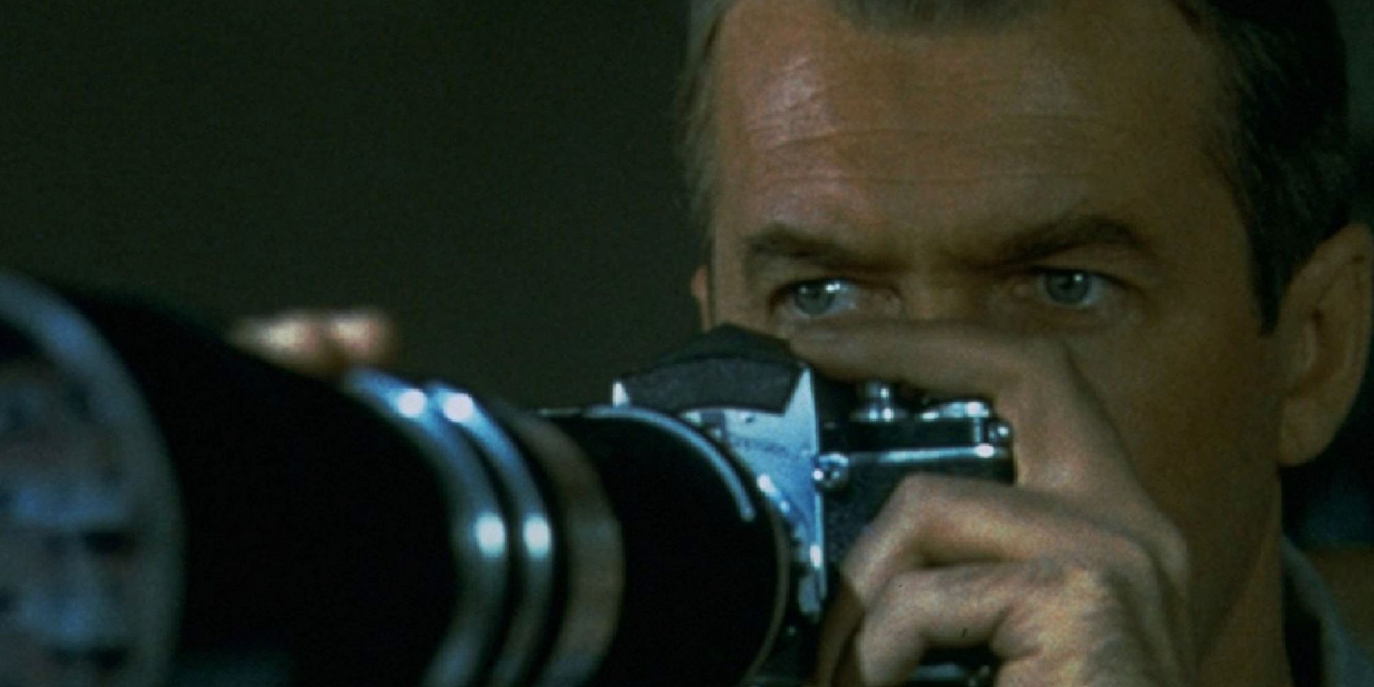 James Stewart peers over the top of his camera as he spies on his neighbors in Rear Window