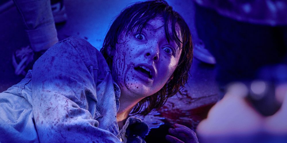 Lila hides in fear with blood on her face in Texas Chainsaw Massacre 2022