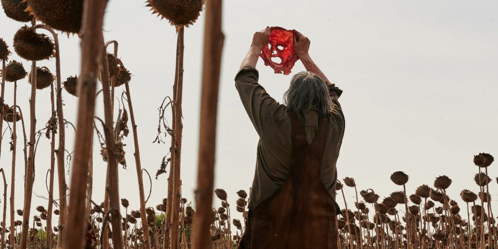 Leatherface holds up Mrs. Mc&rsquo;s face in Texas Chainsaw Massacre 2022