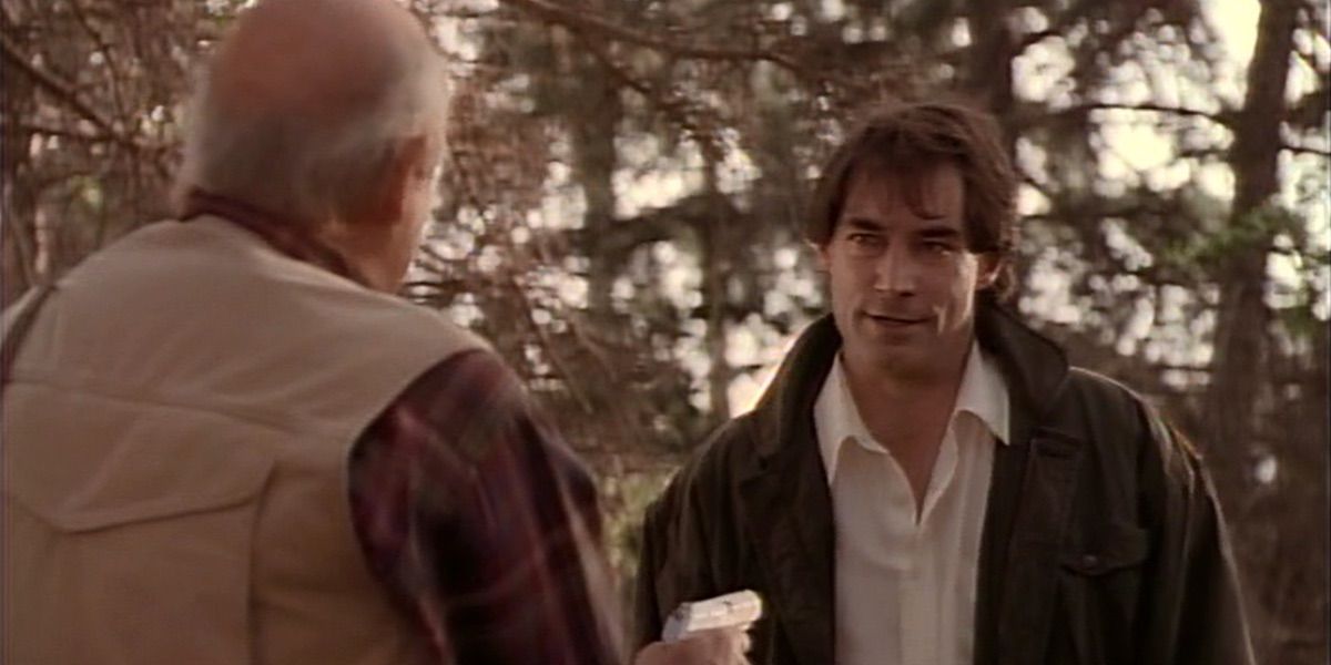 A man points a gun at Timothy Dalton in Tales from the Crypt
