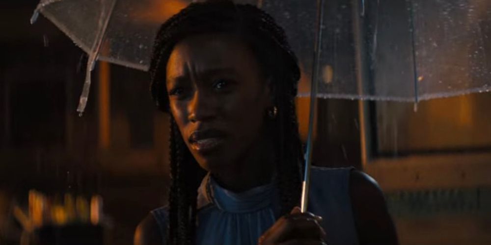 Catherine holds an umbrella in the rain in Texas Chainsaw Massacre 2022