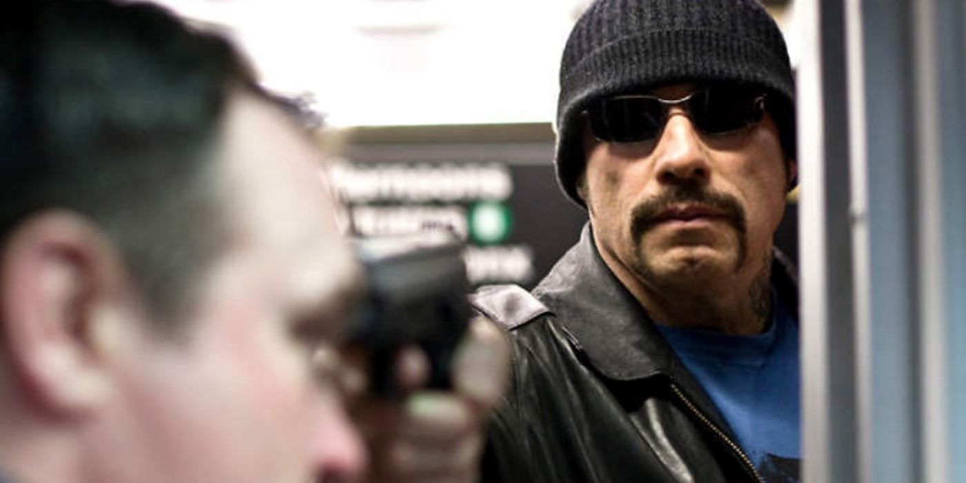Blue pointing a gun at someone in The Taking Of Pelham 123