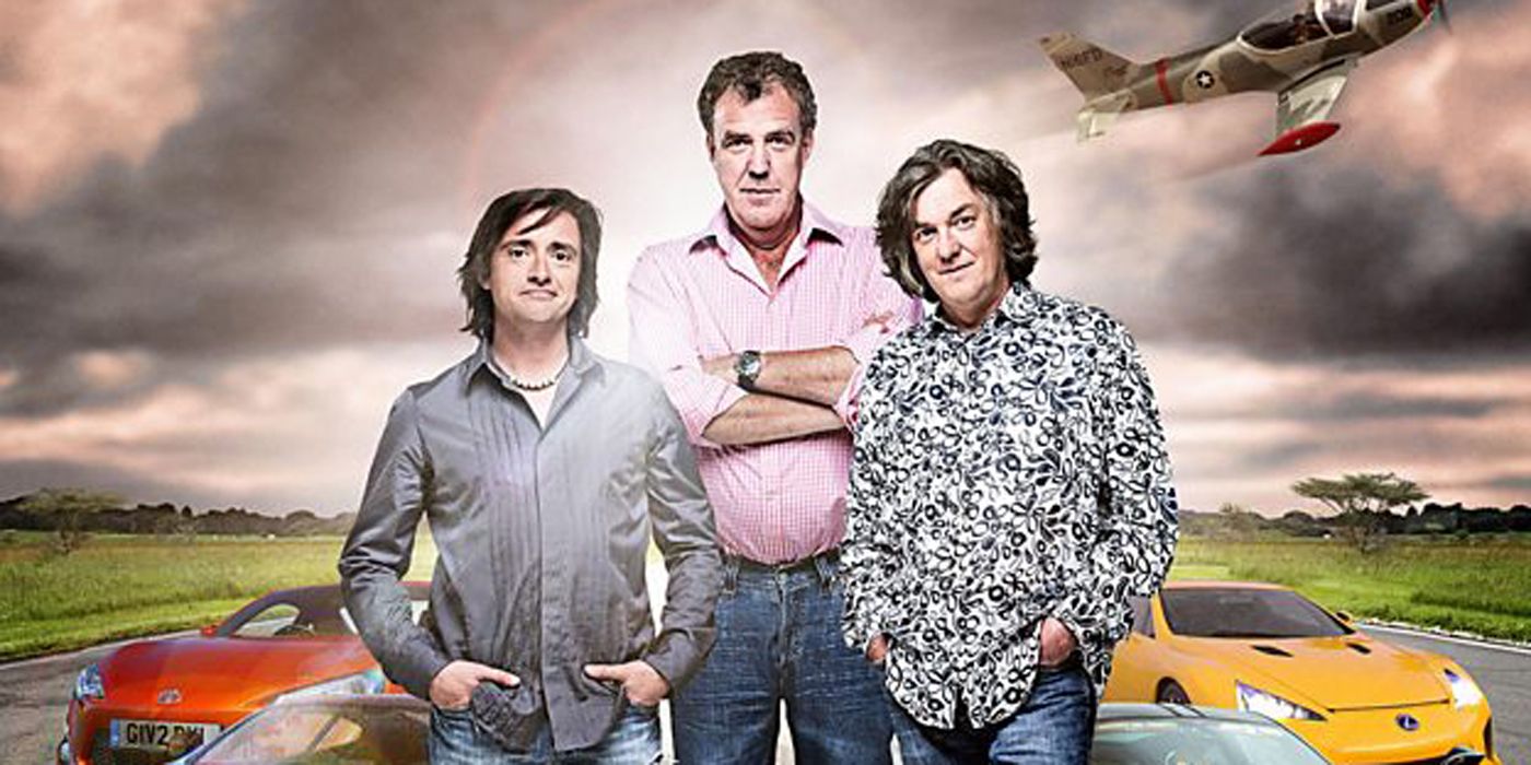 The Top Gear crew in front of cars.