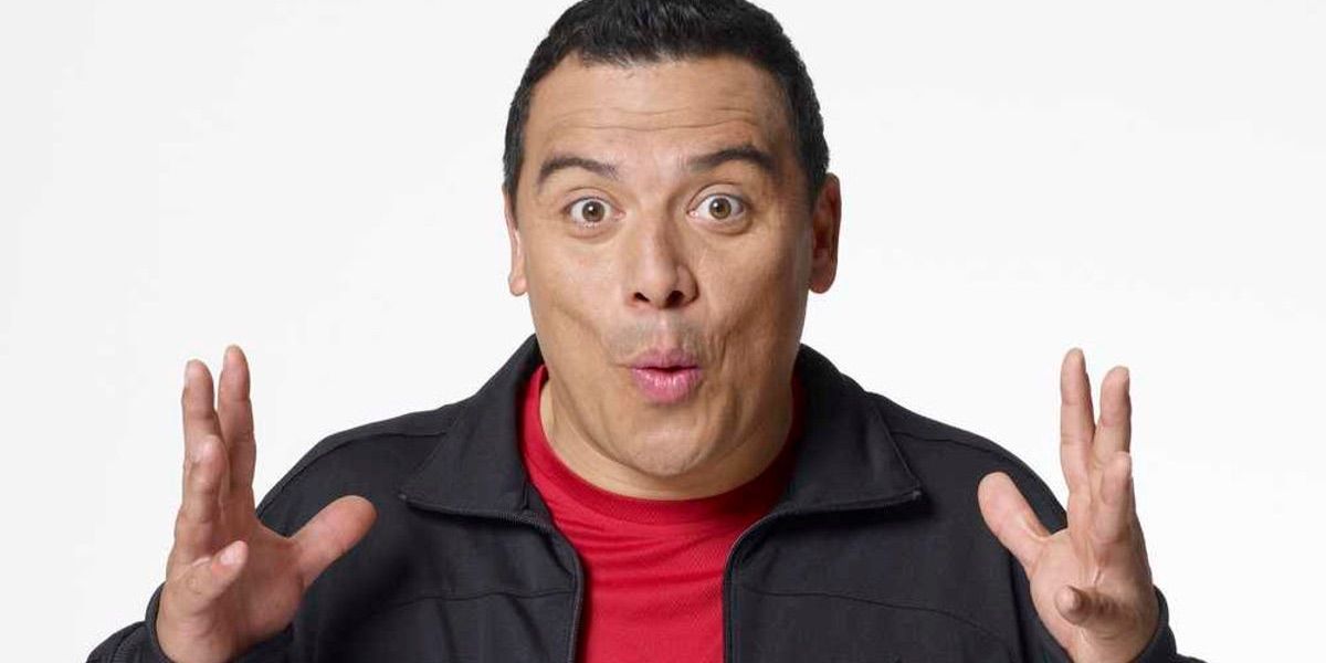 Carlos Mencia poses in front of a white background