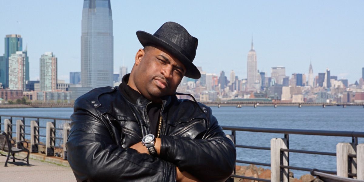Patrice O'Neal poses in front of a city skyline