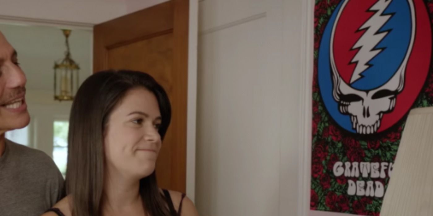 Abbi standing near a Grateful Dead poster in Broad City.