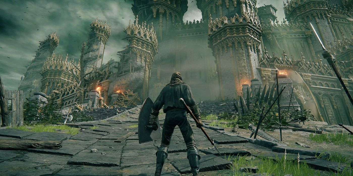 A player with a shield and spear standing in front of castle ruins in Elden Ring.