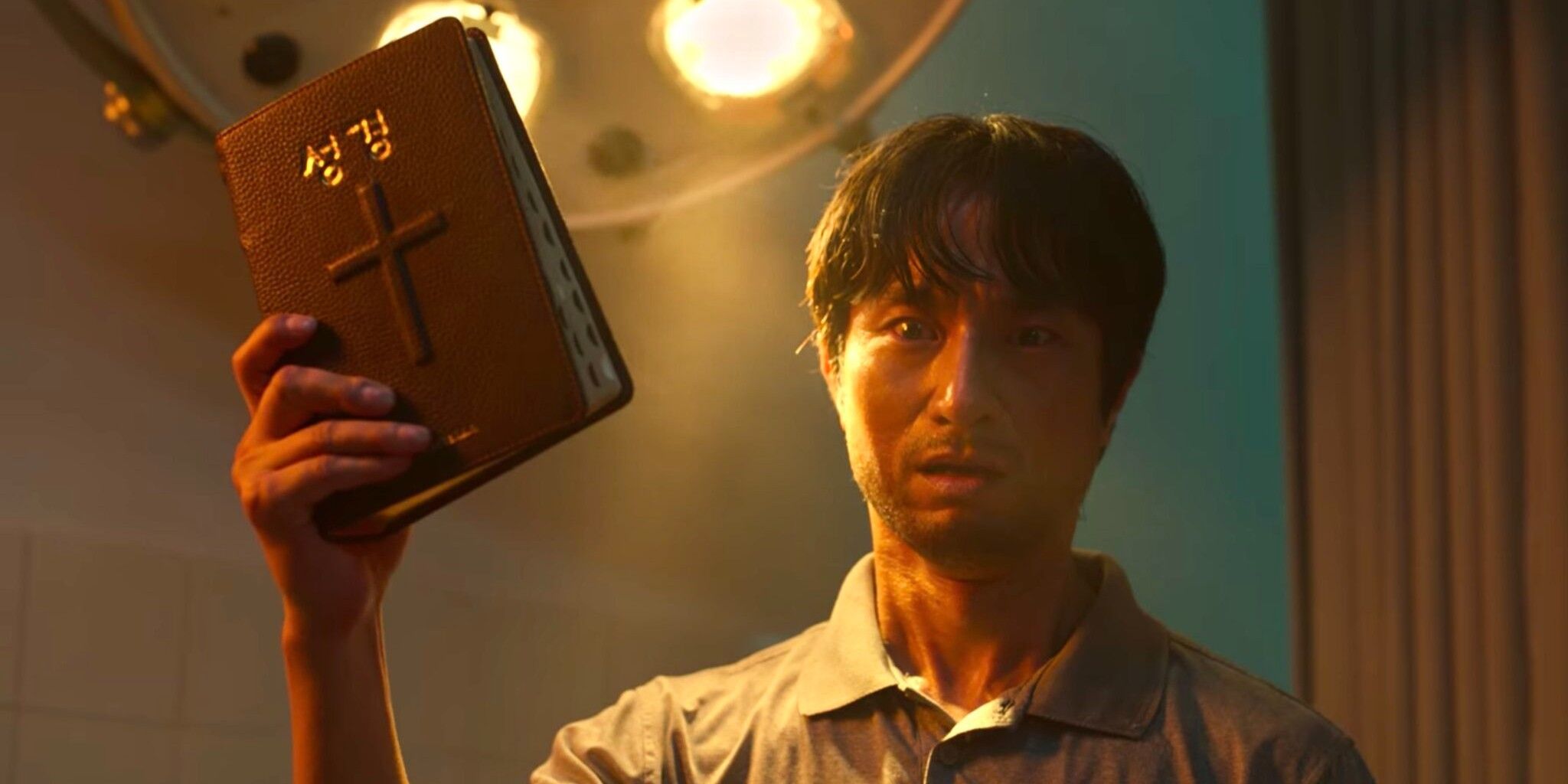 Byeong-chan holding a bible in All of us are dead.
